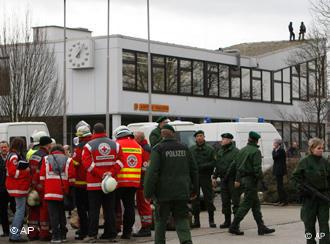 Rescue teams and police forces stand in front of the school where the shooting took place