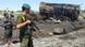 Afghan security forces stand guard near a burnt fuel tanker in Kunduz, north of Kabul, Afghanistan, Friday, Sept. 4, 2009. NATO jet blasted two fuel tankers hijacked by the Taliban in northern Afghanistan, setting off a huge fireball Friday that killed up to 90 people, Afghan officials said. (AP Photo)